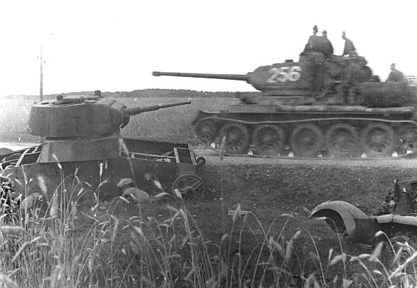 Танк Т-34-85 проезжает мимо подбитого в первые дни войны легкого танка Т-26. Белоруссия, лето 1944 г.